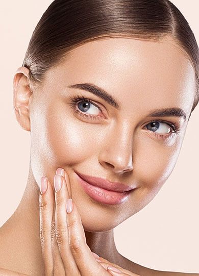 Eine Frau mit makelloser Haut lächelt sanft und berührt ihr Gesicht, als ob sie ein Kosmetikprodukt von Babor genießt.