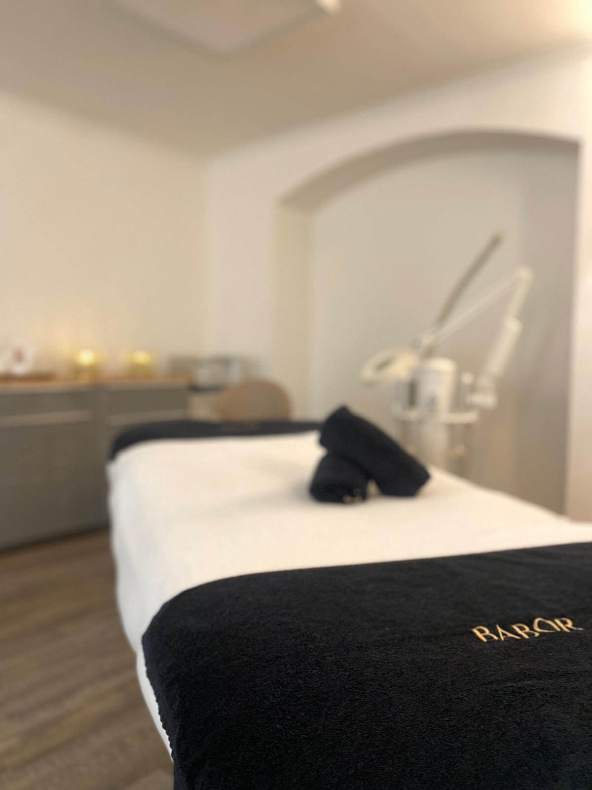 Ein stilvolles Kosmetikstudio mit einem Babor-Handtuch auf einer Behandlungsliege lädt zur Entspannung ein.