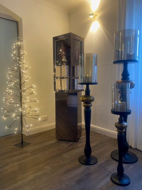 Ein stilvoll dekoriertes Kosmetikstudio mit Babor-Produkten, beleuchtet von eleganten Kerzenständern und einem leuchtenden Baum.