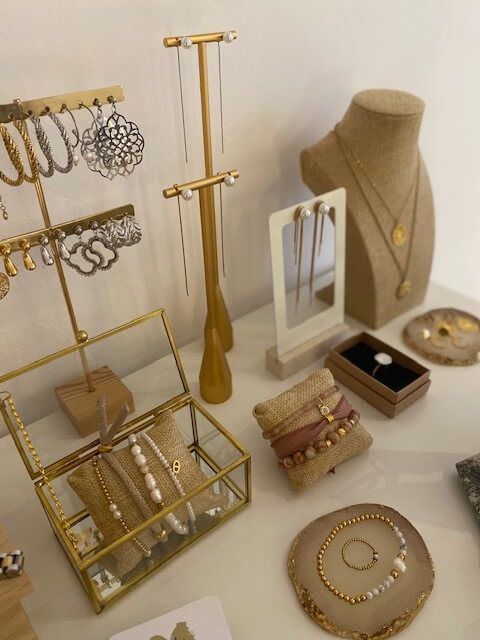 Eine stilvolle Schmuckauslage mit Ohrringen und Armbändern präsentiert sich im Kosmetikstudio neben Babor-Produkten.