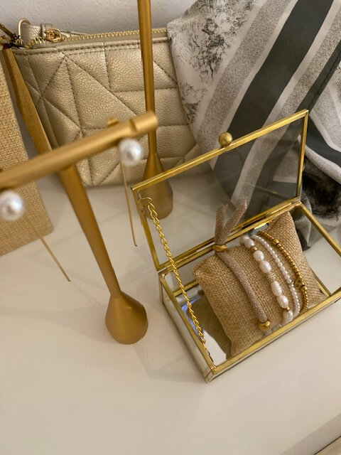 Eleganter Schmuck mit Perlen und goldenen Details, stilvoll arrangiert auf einem Tisch im Kosmetikstudio.